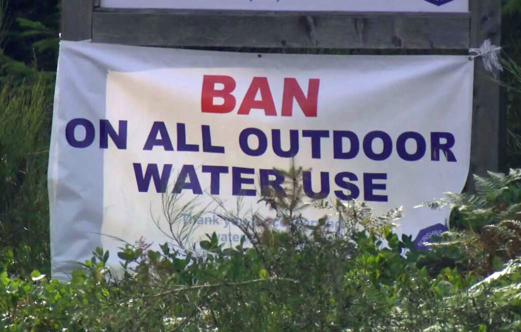 Banner hanging in public view, that reads "Ban on all outdoor water use".