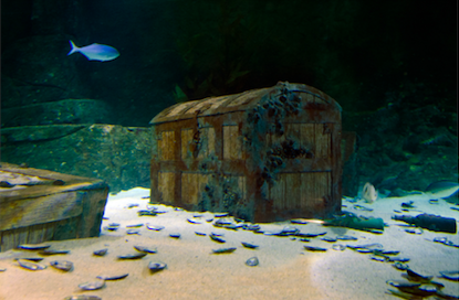 A graphic image of an old wooden trunk at the bottom of the ocean.