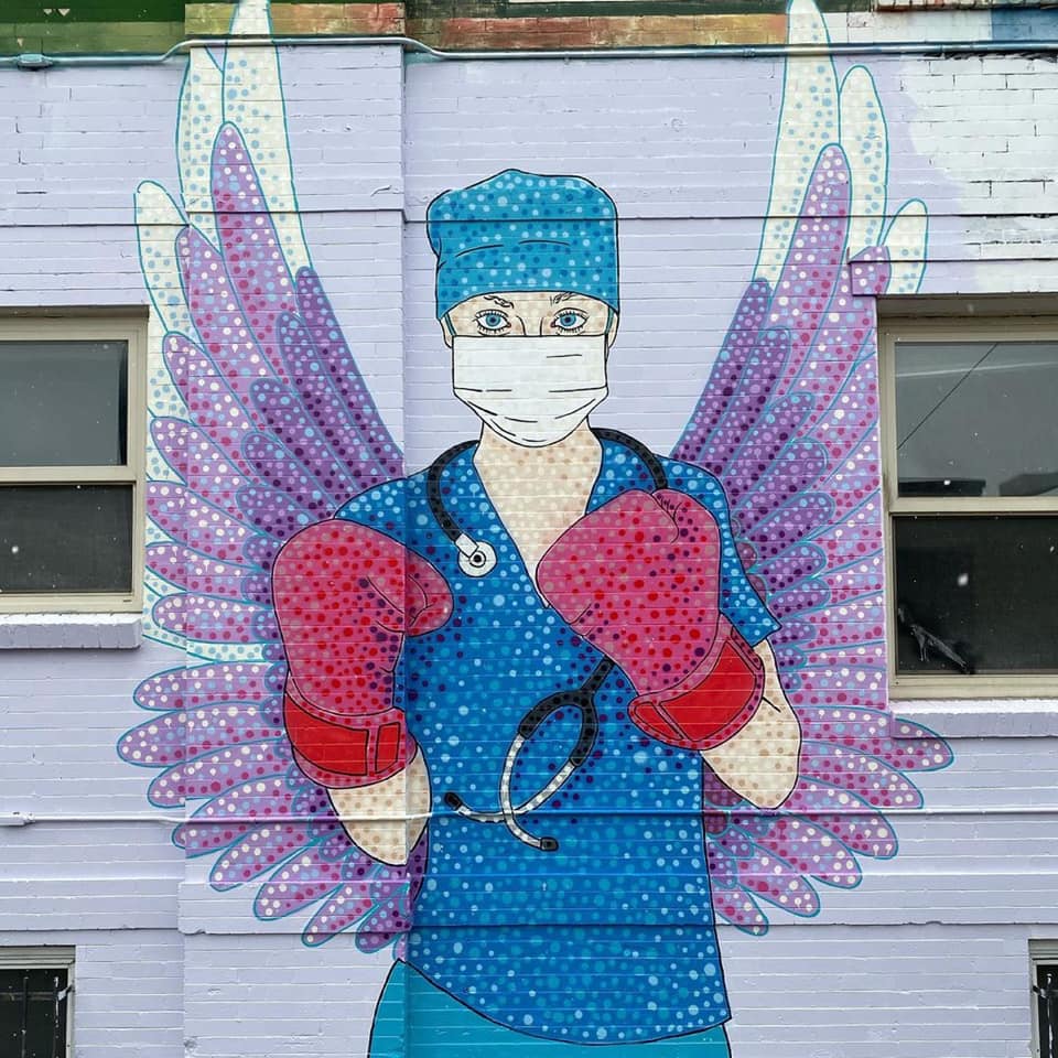 Mural of health care worker with wings and boxing gloves.