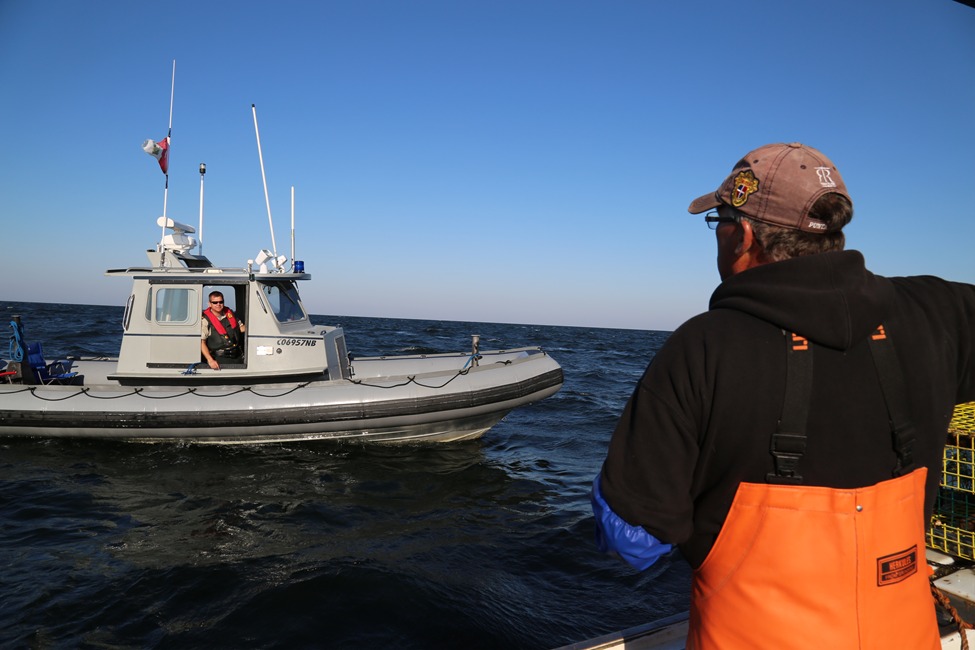 A DFO Officer checks in with a fisherman to ensure compliance with fishing regulations. Through regular inspections and enforcement of regulations, DFO officers work to protect the health and abundance of our marine resources.