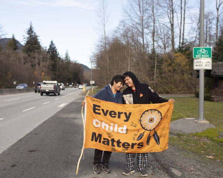 Kimberly (left) and Jordan Joseph on Highway 99, Sḵwx̱wú7mesh (Squamish). The couple planned a walk from “Prince Rupert” to “Victoria” raising awareness for indigenous children in foster care